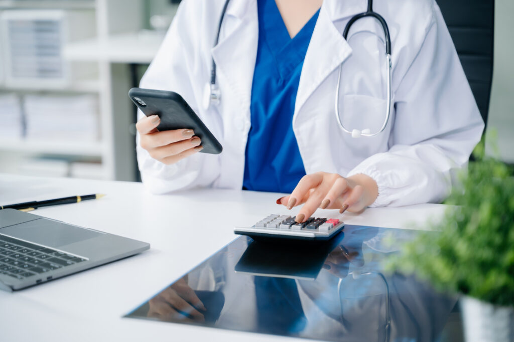 Doctor calculating reimbursement details as part of chiropractic billing services